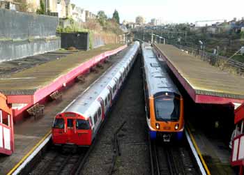 Underground and Overground trains pass at Kensal Green station.