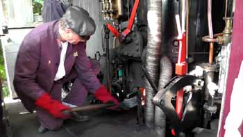 GWR Railmotor shovelling coal into vertical boiler .